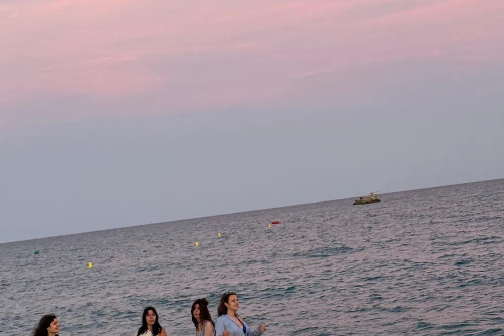 participants walking along the beach in Malgrat de Mar at sunset