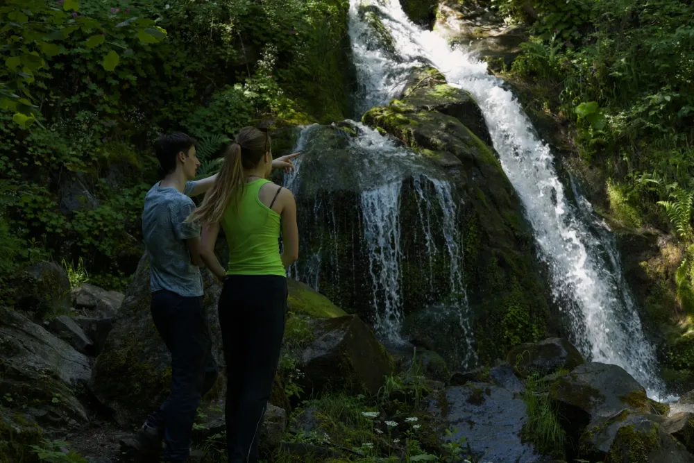 two participants pointing out a waterfall on a nature walk near Bansko