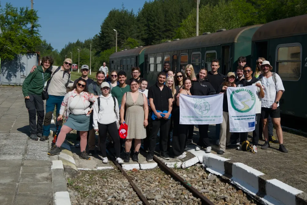 the full Green Pathways group at Bansko train station, holding the Sustainable for the Future Foundation and Green Pathways project banners